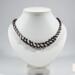 Black and white Kumihimo necklace on white bust, spiral beaded design using traditional 7-warp Japanese Kumihimo braiding